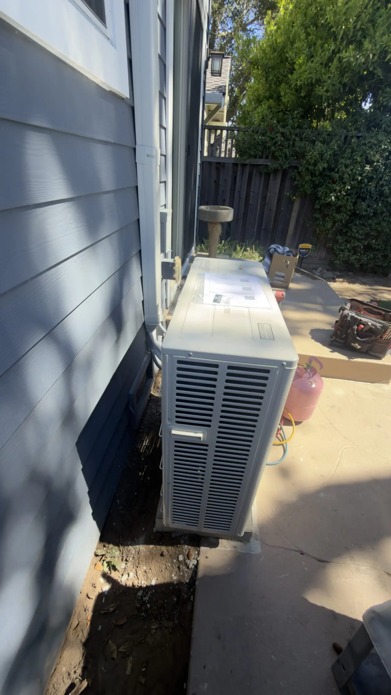 Mitsubishi outdoor heat pump unit set on new concrete pad in San Carlos