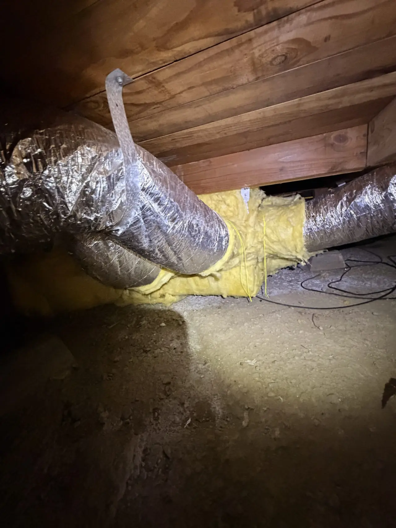 New ductwork wrapped and sealed under a San Bruno home for the heat pump system