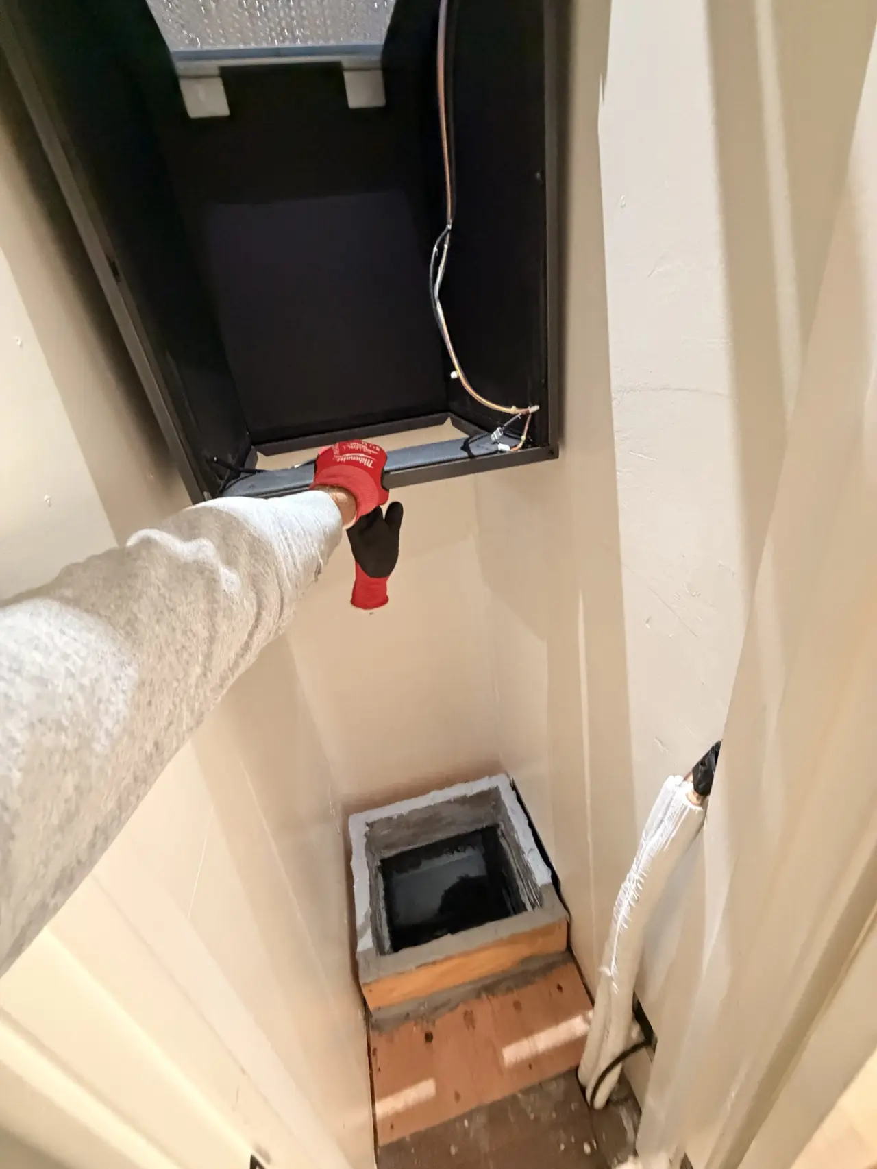 Technician positioning the Mitsubishi heat pump air handler cabinet in a San Bruno home