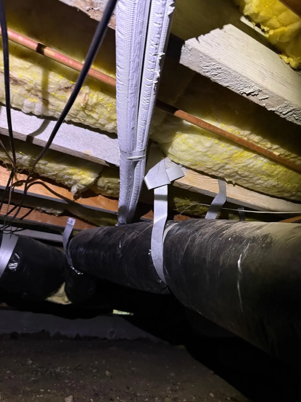 Insulated Mitsubishi heat pump line set strapped beside existing ductwork in a Palo Alto crawlspace