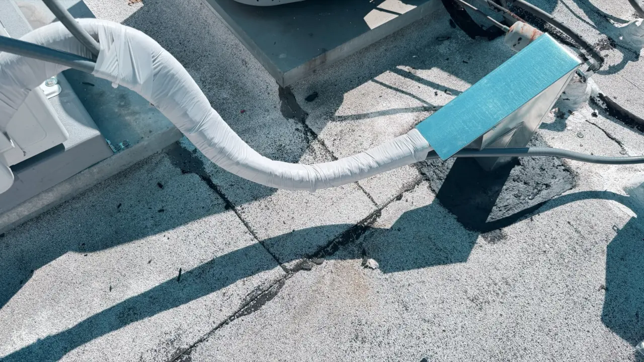 Insulated refrigerant lineset routed across a Burlingame rooftop to a heat pump