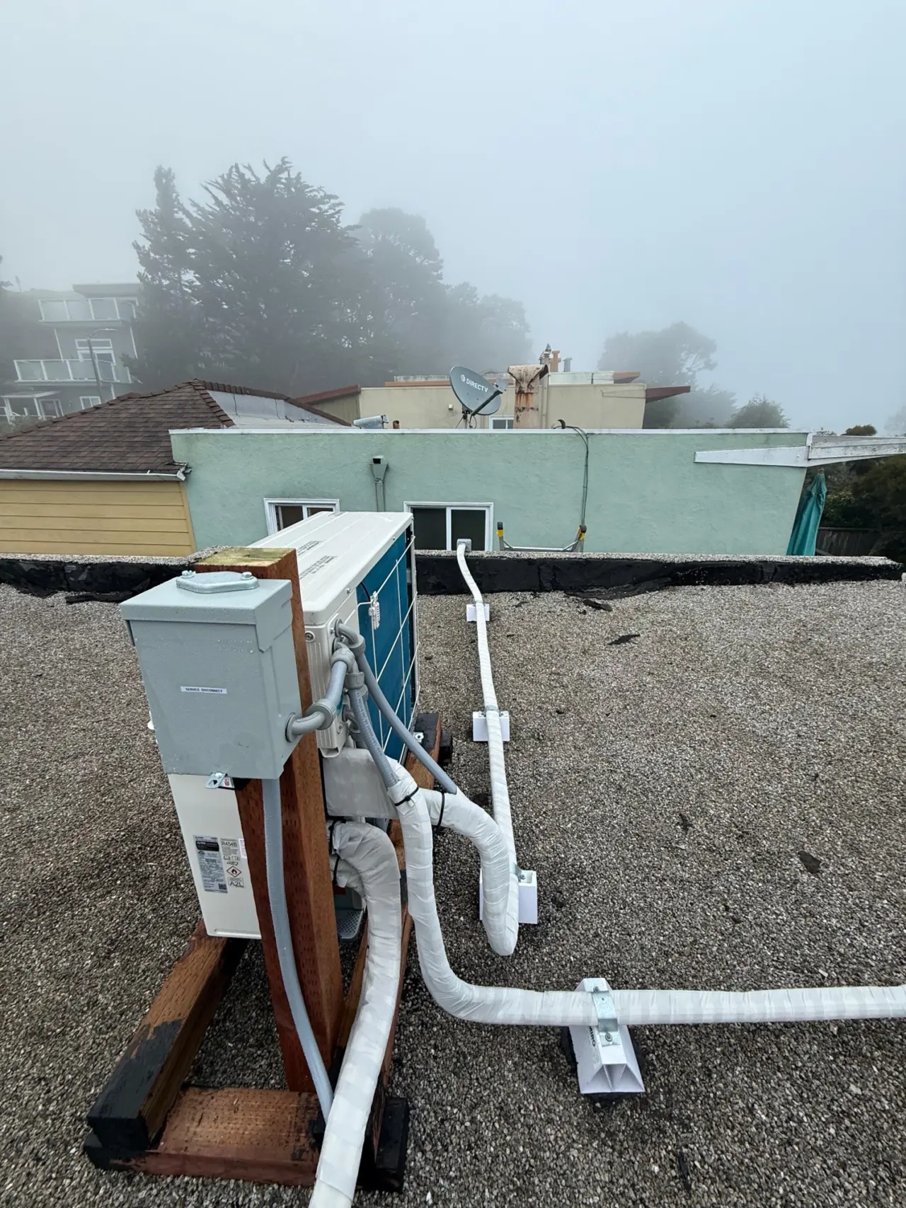 Mitsubishi ductless mini-split heat pump condenser installed on a San Francisco rooftop