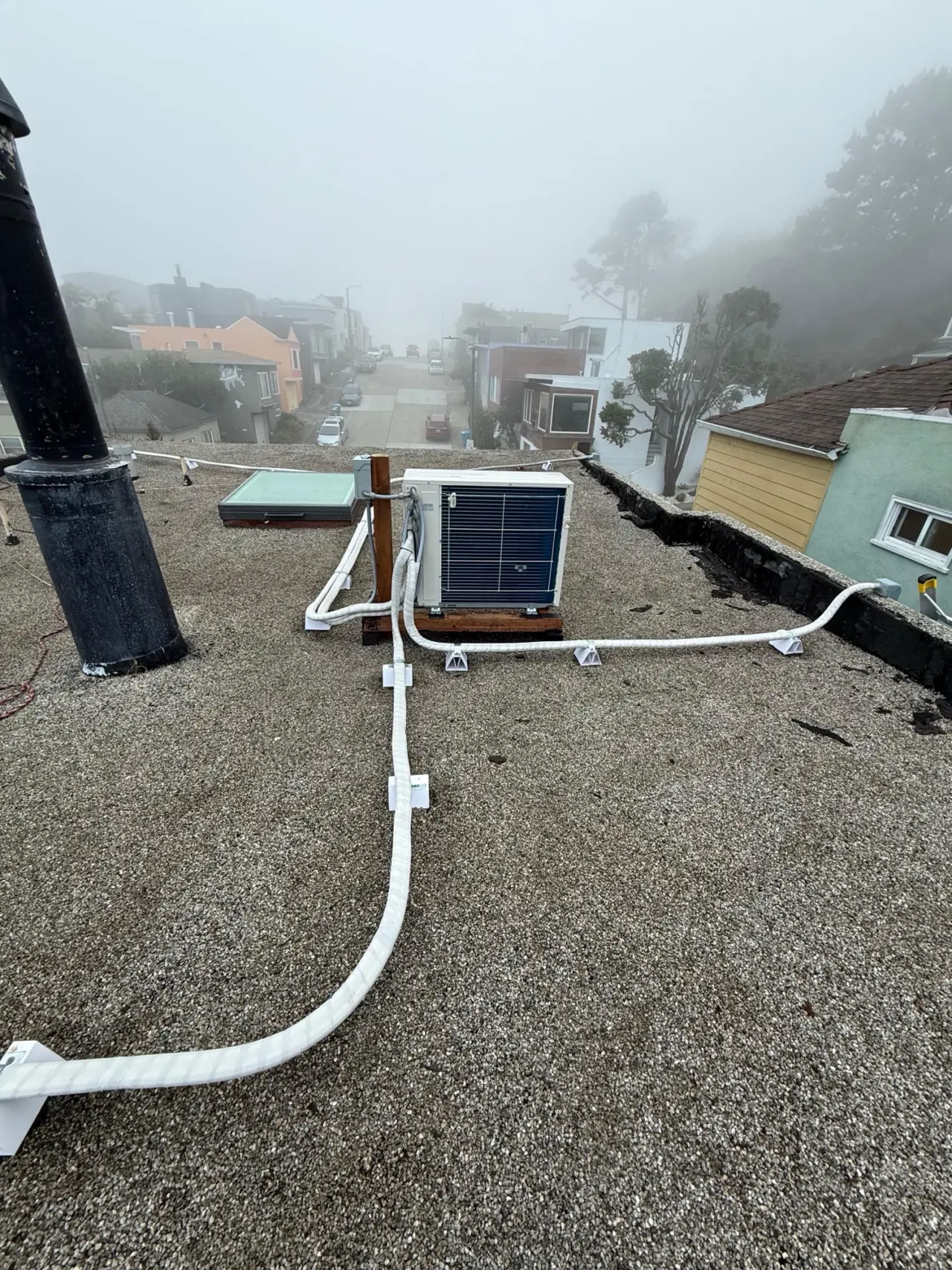 Mitsubishi mini-split condenser and insulated line sets routed across a San Francisco roof