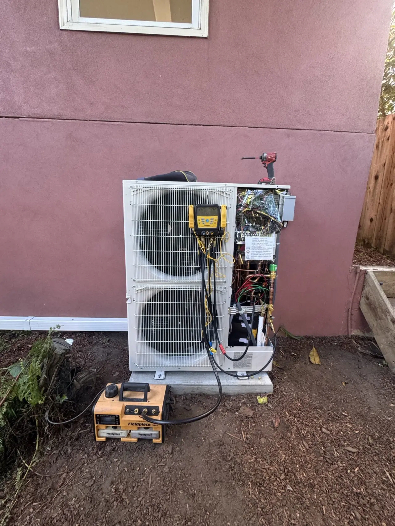 Mitsubishi multi-zone heat pump condenser being installed outside a San Francisco home