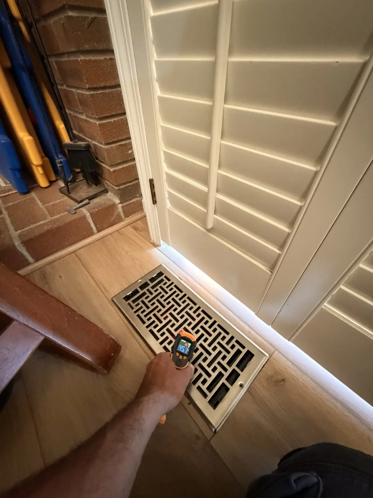 Technician checking airflow at a ceiling supply register after a Sunnyvale heat pump installation