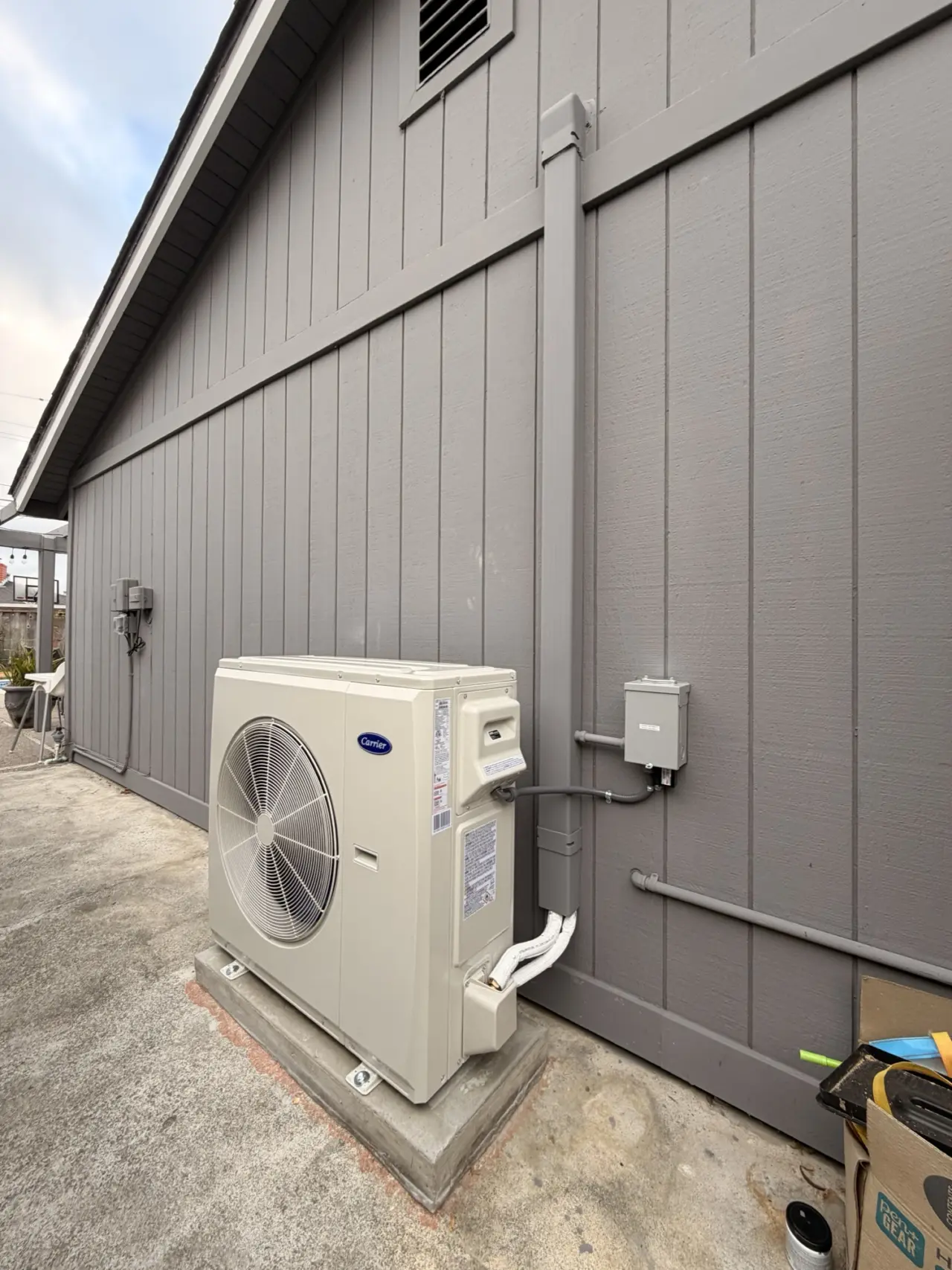 Carrier 4-ton heat pump condenser installed on a concrete pad outside a San Mateo home