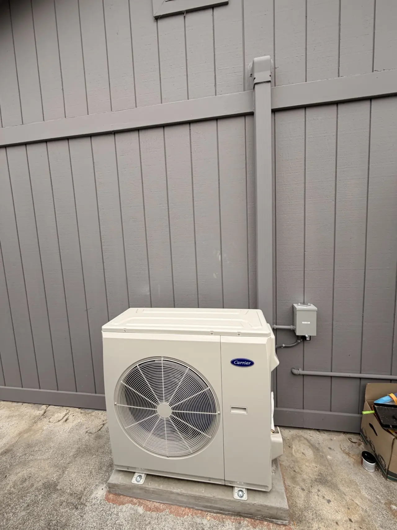 Carrier heat pump condenser and electrical disconnect on the side of a San Mateo house