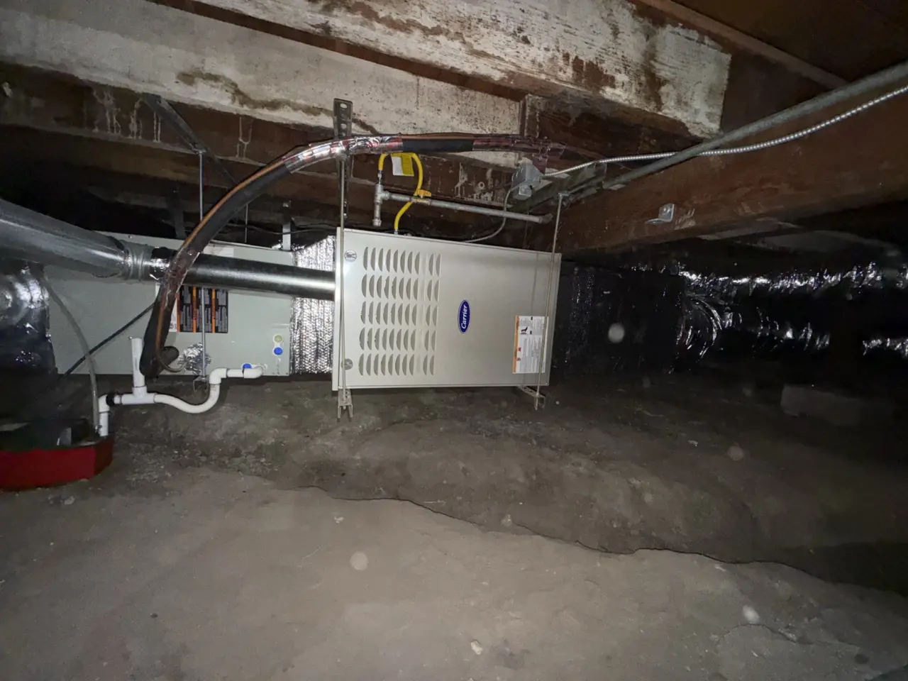 New Carrier furnace connected to the gas line and ductwork in a Burlingame crawlspace