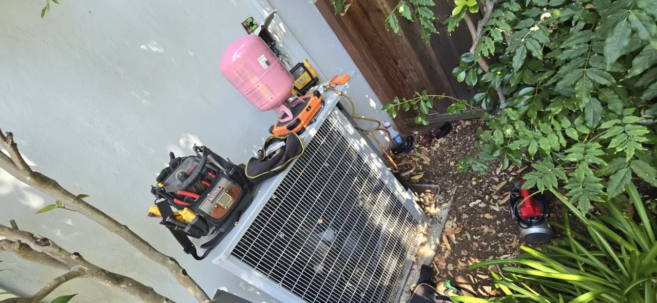Refrigerant recovery and recharge setup at an outdoor HVAC condenser in Los Altos