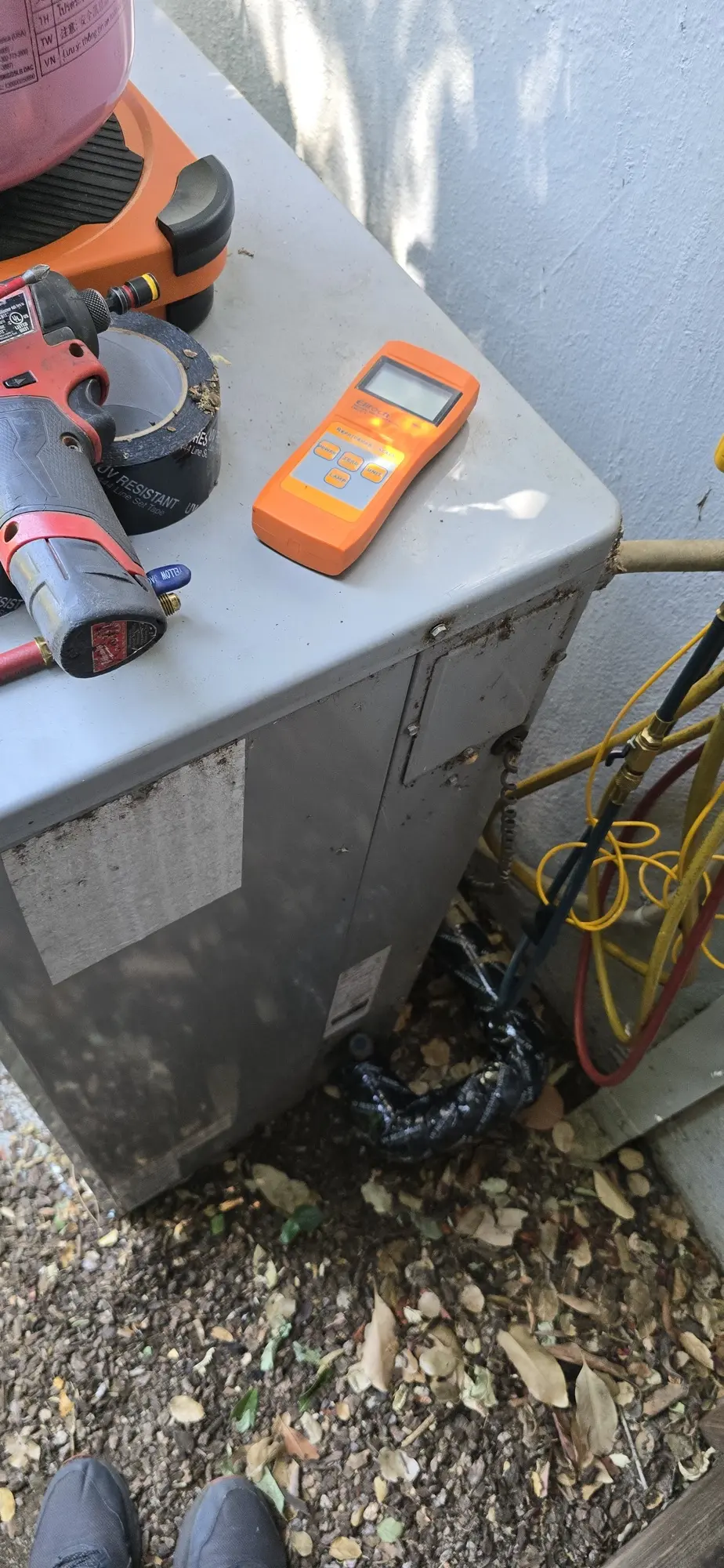 Leak detection tools on top of an HVAC condenser during a suction line repair in Los Altos