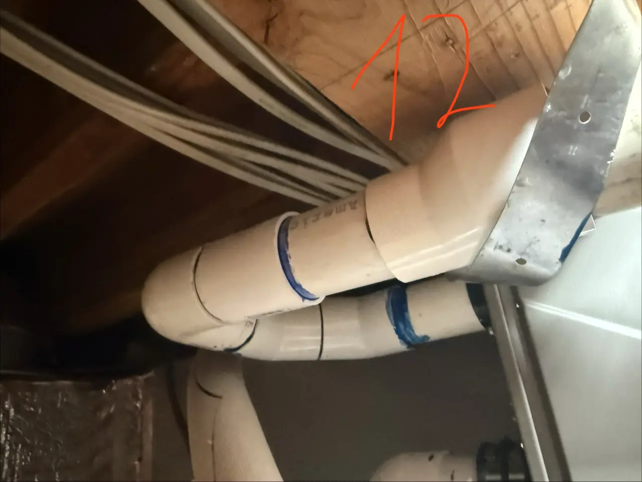 Freshly installed PVC condensate piping near the return duct in a Palo Alto home