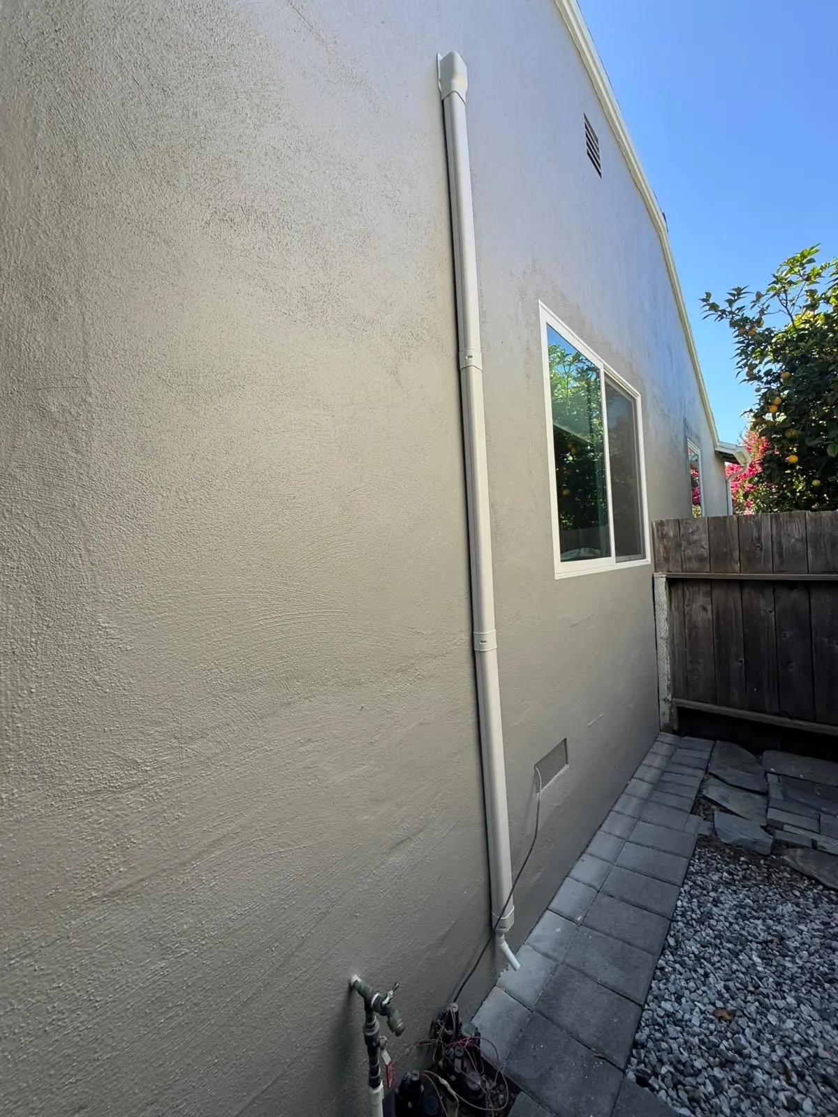 Line set cover running along exterior wall after heat pump installation in San Mateo