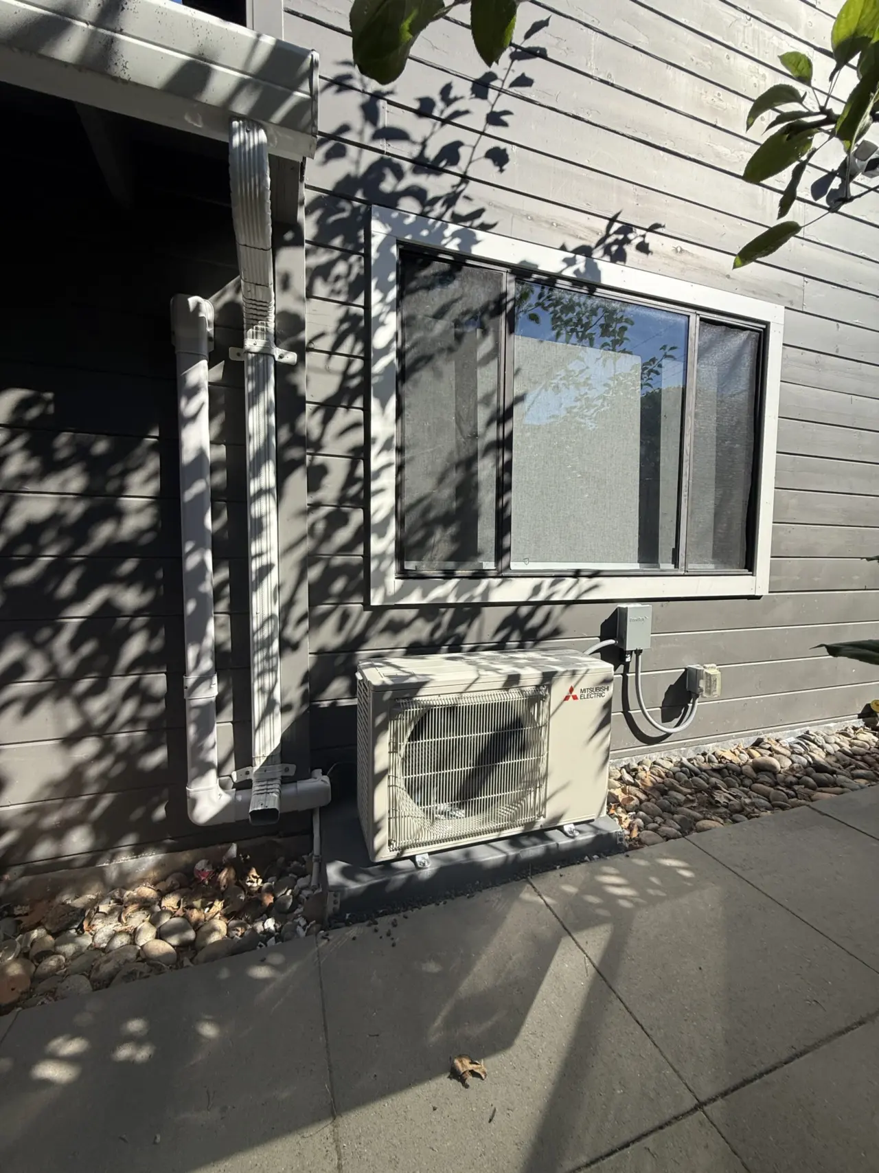 Finished Mitsubishi heat pump outdoor unit against siding, Palo Alto residence
