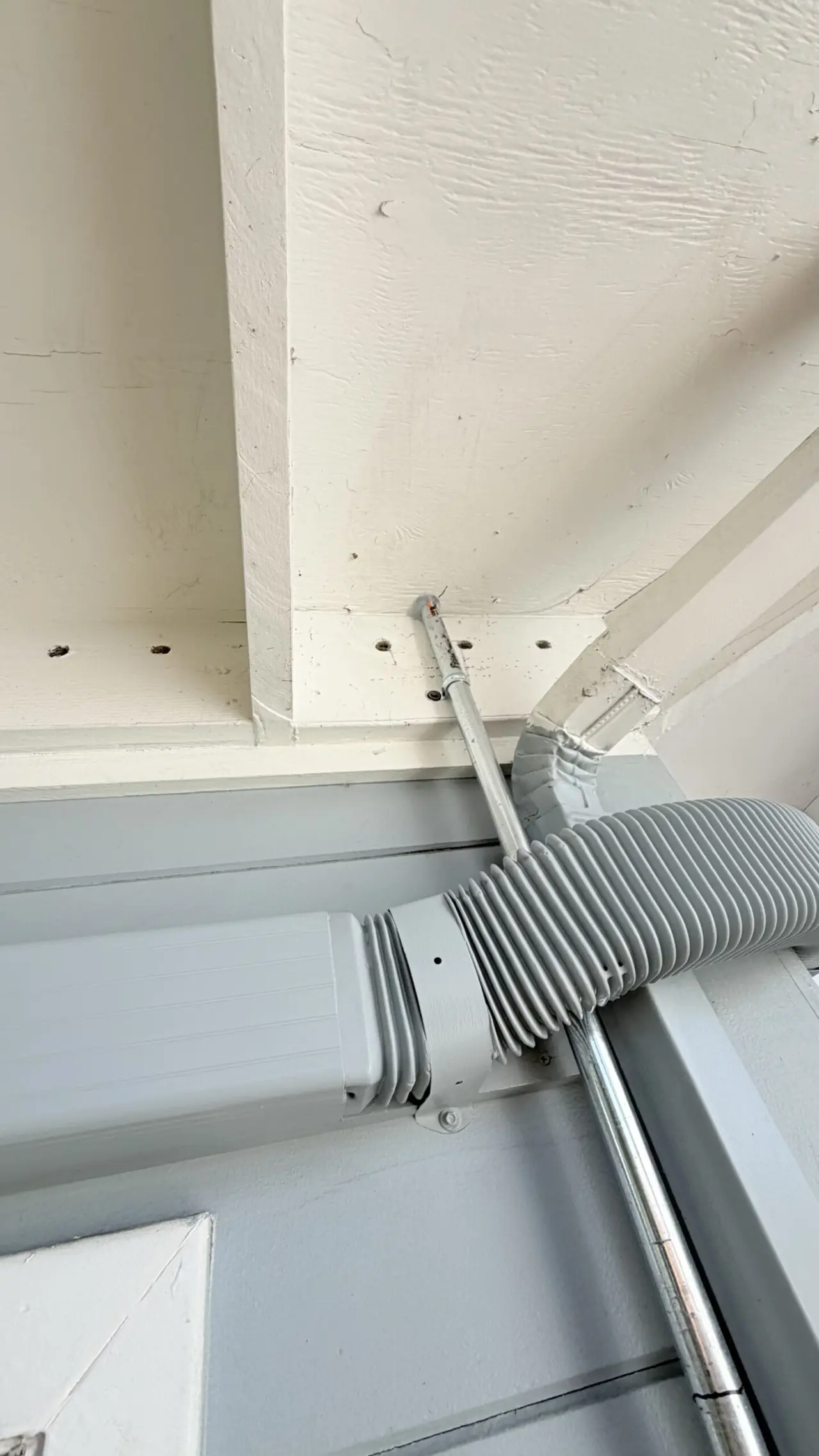 Close-up of insulated refrigerant line entering wall for heat pump installation, San Mateo