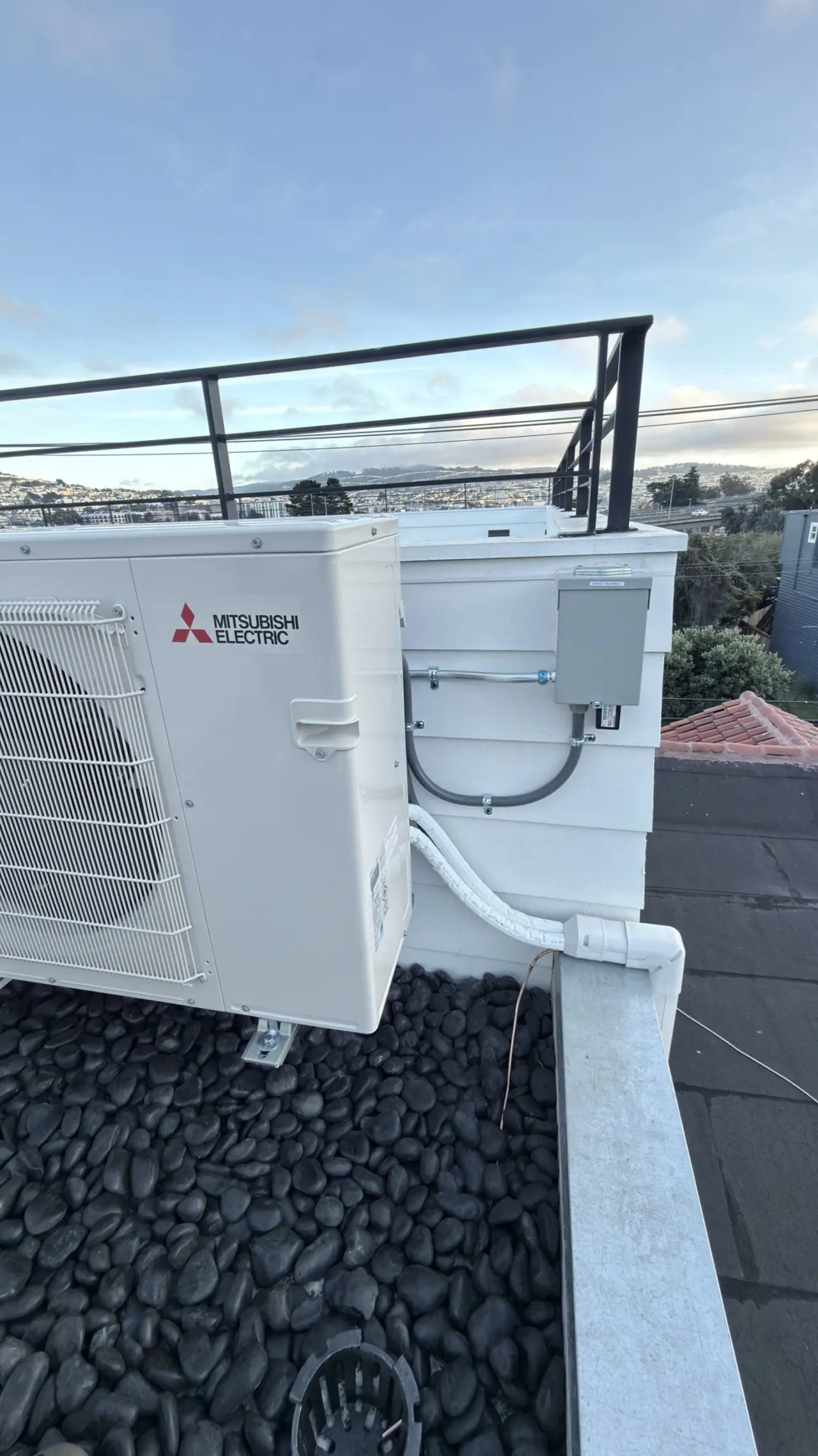 Mitsubishi ductless condenser and disconnect box mounted on San Francisco rooftop siding