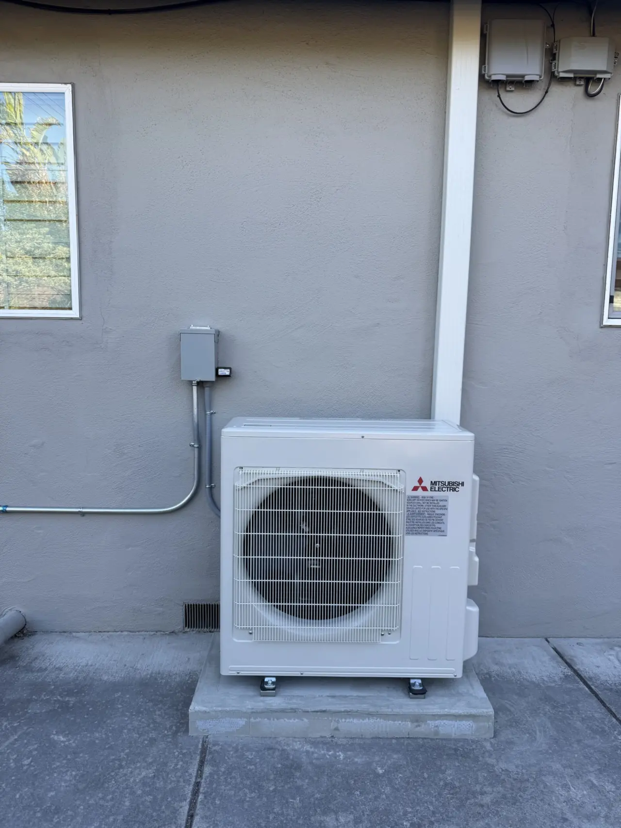 Mitsubishi heat pump outdoor unit installed on new concrete pad in Santa Clara backyard