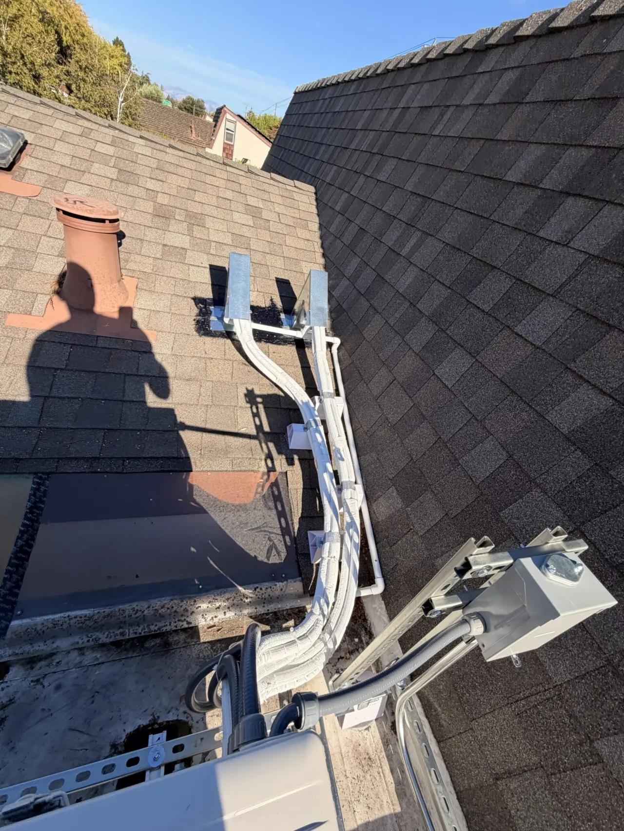 Mitsubishi heat pump line set and disconnect box routed along rooftop ridge in Cupertino