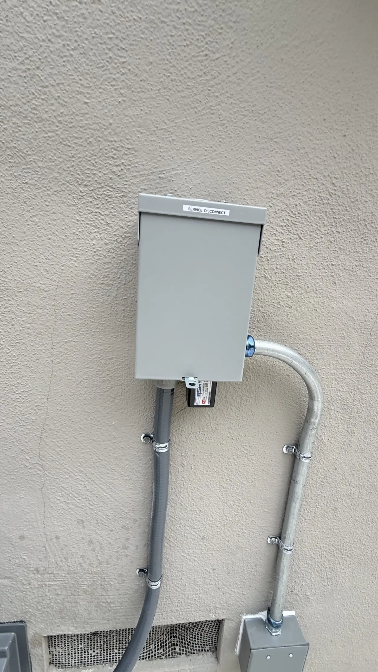 Heat pump service disconnect with surge protective device and strapped conduit in San Mateo