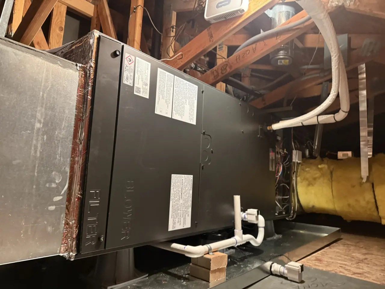 Side view of the new Mitsubishi heat pump air handler with insulated line set and condensate drain in a South San Francisco attic